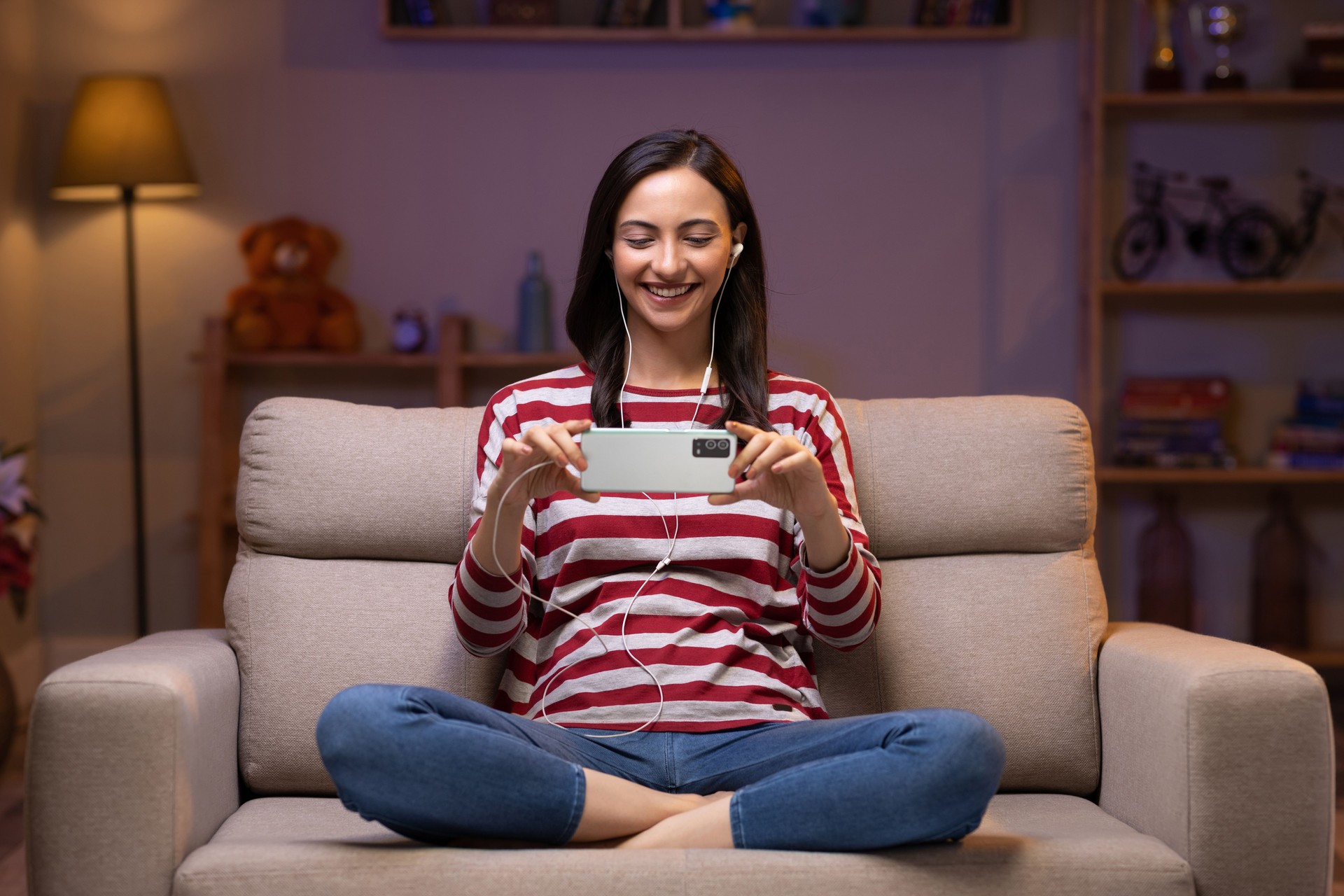 Young woman listening music mobile phone at home stock photo